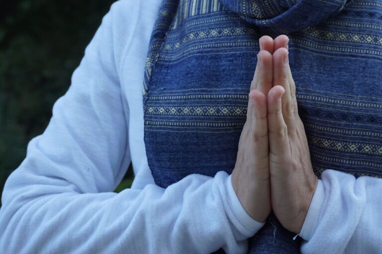 a woman with her hands folded in prayer