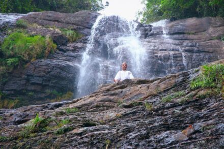Spiritual Healing Journey: Into 3 man in white shirt sitting on brown rock near waterfalls during daytime