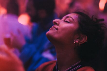 a woman with her eyes closed in a crowd
