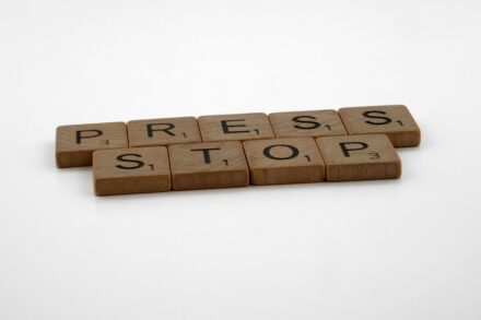 a set of wooden blocks spelling press and stop