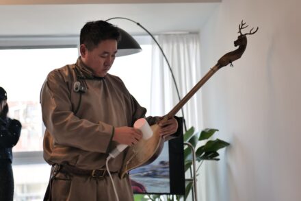 A man plays a traditional musical instrument.