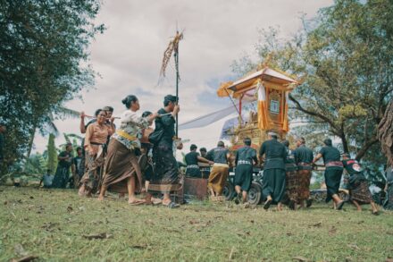 People carrying a decorated carriage in a procession