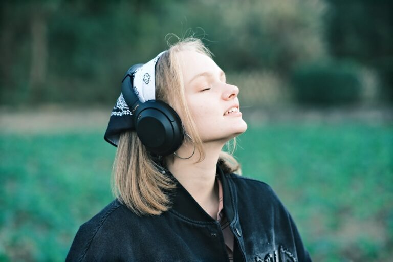 a woman wearing headphones in a field of grass