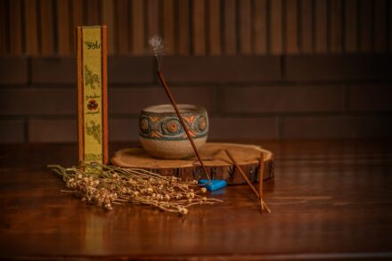 a wooden table topped with a bowl and two sticks