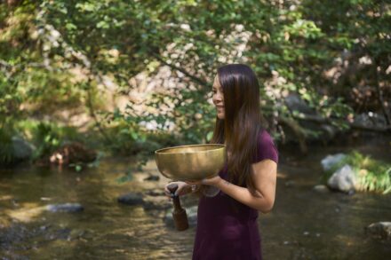 Energy Healing A woman in a purple dress is holding a bowl
