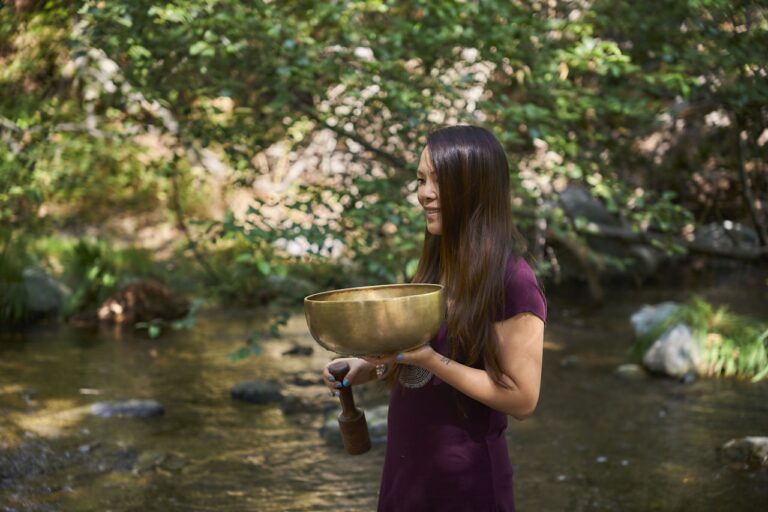 Energy Healing A woman in a purple dress is holding a bowl