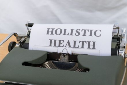 Key Holistic Health 1 a close up of a typewriter with a paper that reads holstic health