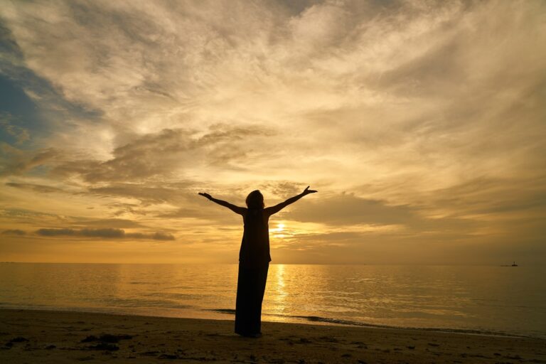 Yoga silhouette of woman standing on beach during sunset