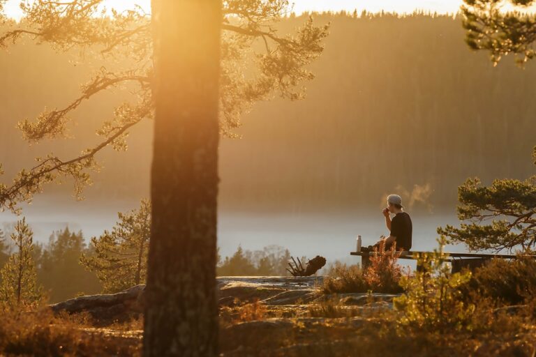 Yoga man sitting on bench near body of water during daytime